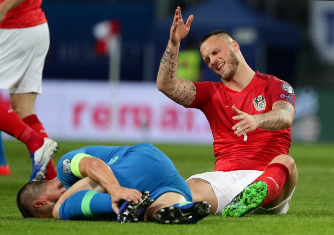 Marko Arnautović se jezi na slovenskega kapetana Bojana Jokića v bolečinah. FOTO: Reuters