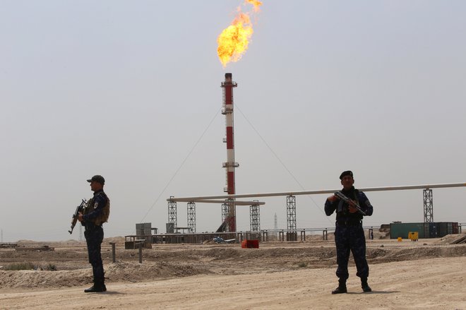 Člana iranske revolucionarne garde varujeta naftna polja v Iranu.