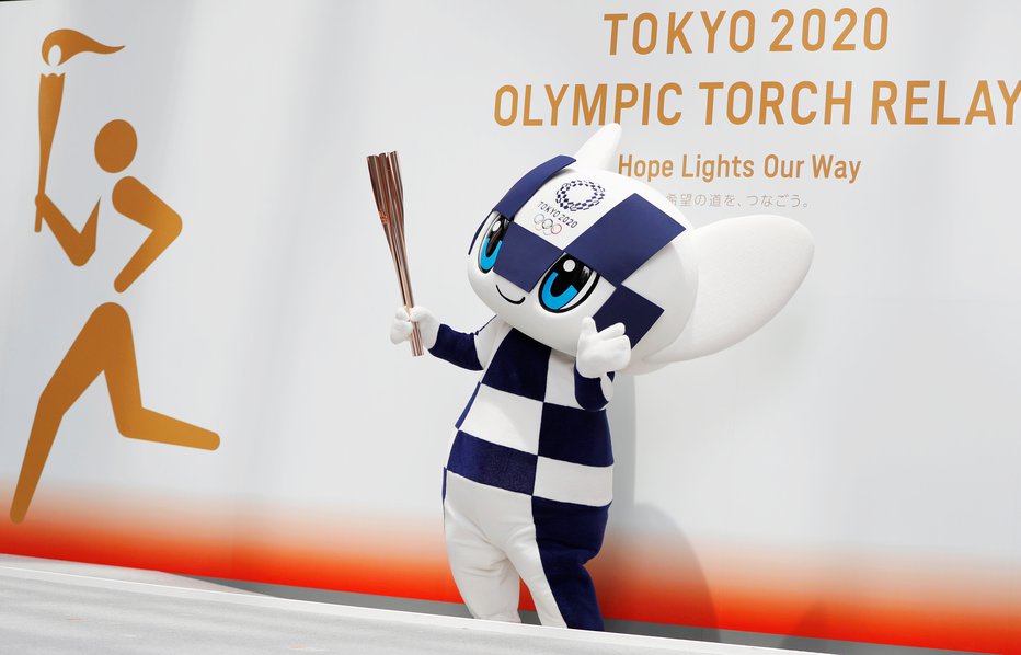 Fotografija: Maskota iger Miraitova drži olimpijsko baklo. FOTO: Reuters