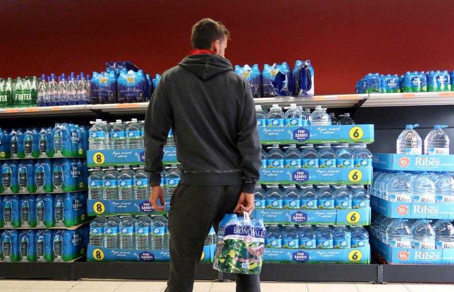 Fotografija: Ljudje še vedno na veliko kupujejo vodo v plastenkah. FOTO: Reuters