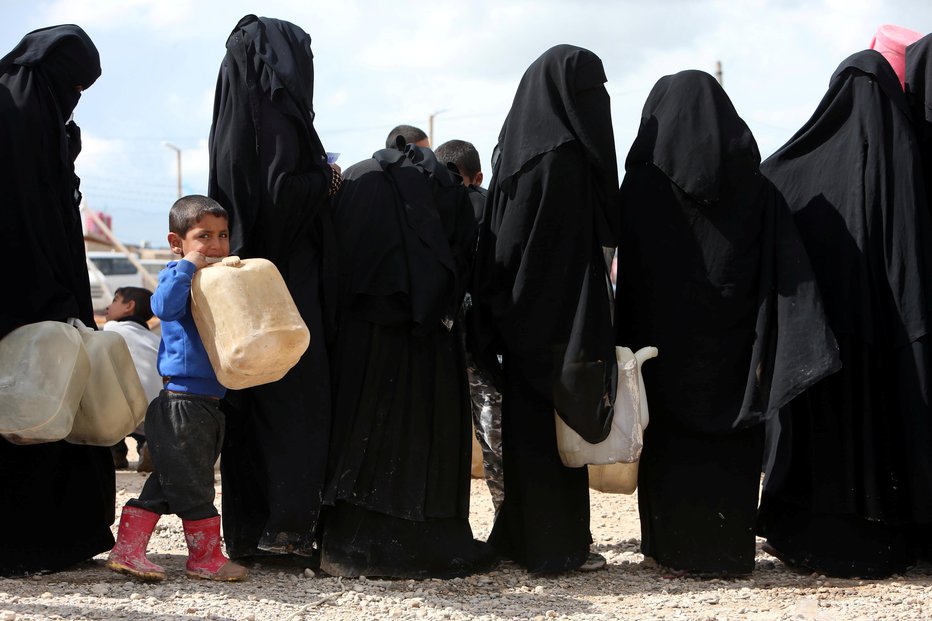 Fotografija: Žene in otroci pripadnikov Islamske države čakajo na vodo v taborišču Hasaka v Siriji. FOTO: Reuters