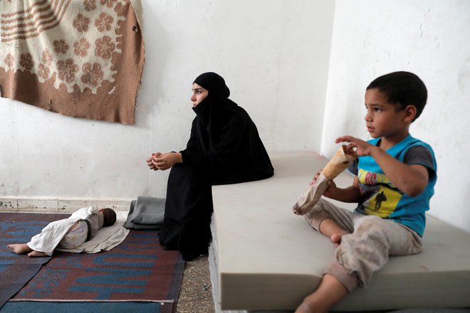 Žena in otroka nekdanjega pripadnika Islamske države v taborišču v Siriji FOTO: REUTERS