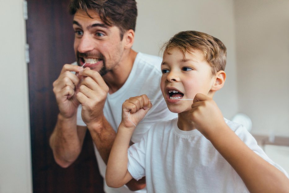Fotografija: Poleg krtačke uporabljamo interdentalno ščetko in zobno nitko, njeno uporabo naučimo tudi otroke.