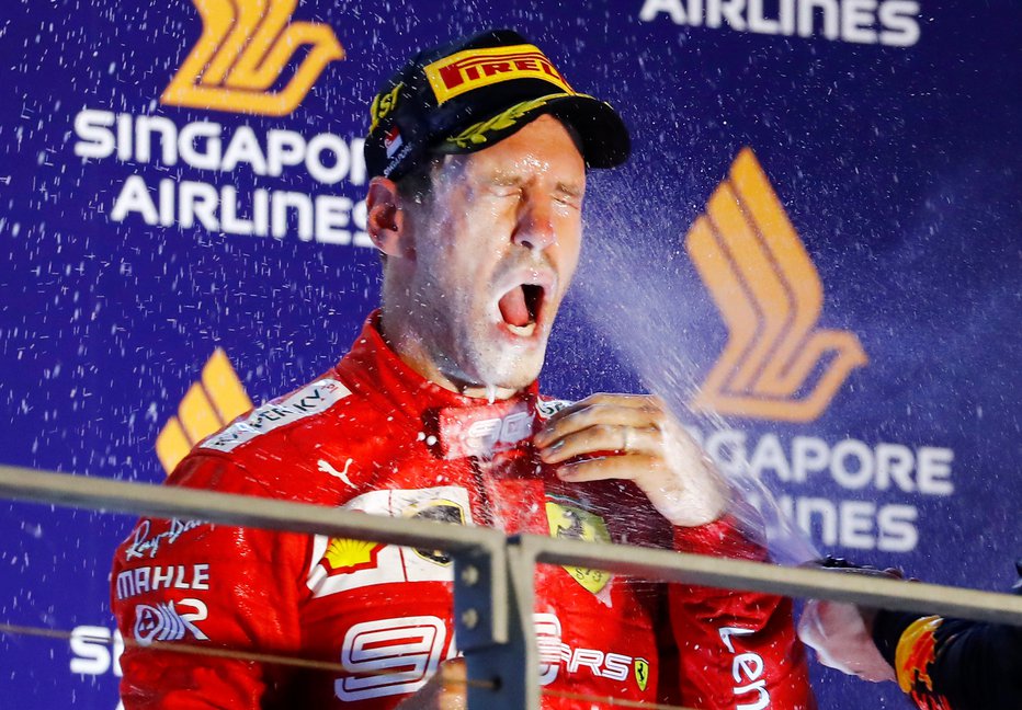 Fotografija: Sebastian Vettel je po debelem letu dni spet užival v zmagoviti šampanjski prhi. FOTO: Reuters