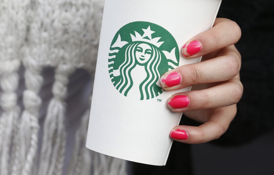 Fotografija: A woman holds a Starbucks takeaway cup in London October 24, 2012. Starbucks's reputation among consumers in Britain has been hit by wave of criticism of its tax affairs from politicians and the media, pollster YouGov said. REUTERS/Suzanne Plunkett (BRITAIN - Tags: BUSINESS FOOD) - RTR39IQG FOTO: Š Suzanne Plunkett / Reuters Reuters