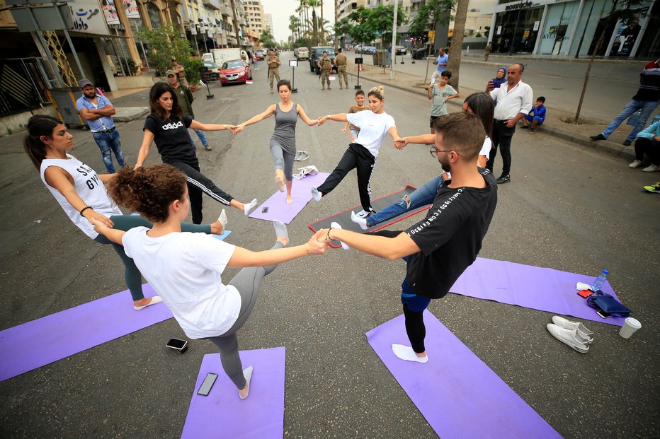 Fotografija: People practice yoga on a street as security forces stand nearby during ongoing anti-government protests in Sidon, Lebanon October 27, 2019. REUTERS/Ali Hashisho FOTO: Ali Hashisho Reuters