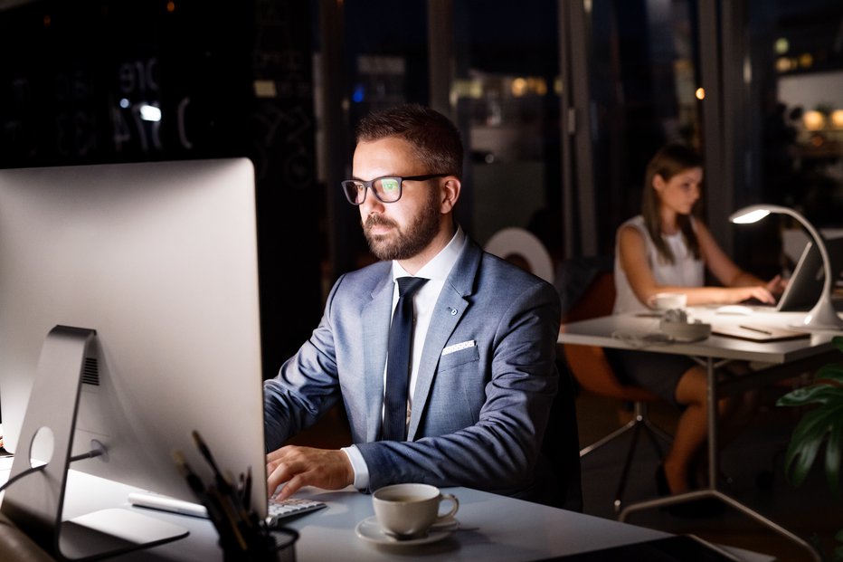 Fotografija: Handsome young businessman in the office with his coworker at night working late. FOTO: Halfpoint Getty Images/istockphoto