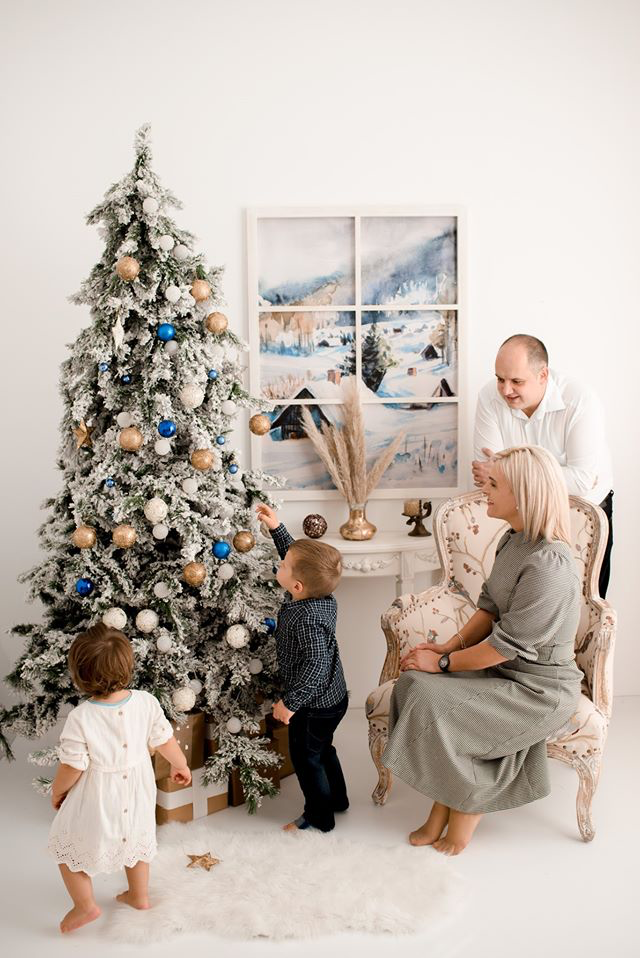 Fotografija: Družina Švab ob novoletni smrečici, pod katero je verjetno tudi pojoča pobarvanka Riši in poj. FOTO: Ana Ravnjak