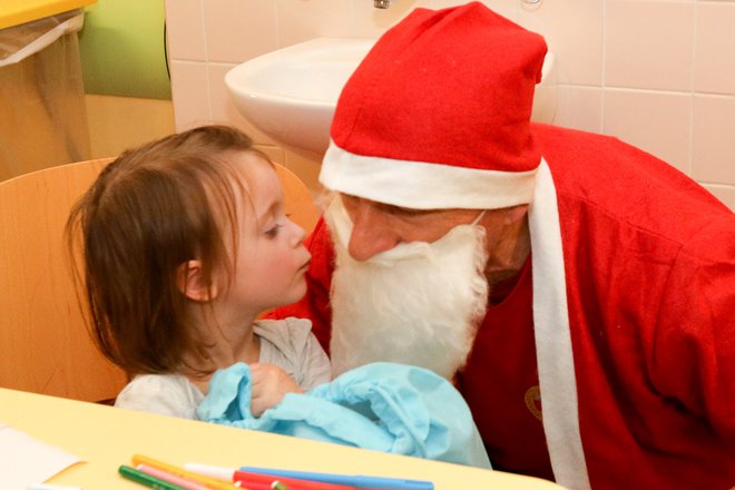 Mala Nika se je razveselila Božička in mu podarila slikico in še poljubček. FOTO: Marko Feist