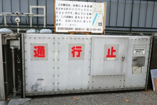 Vrata, na katerih so opazili grafit, preprečujejo poplavljanje v primeru visoke plime. FOTO: Handout/Afp