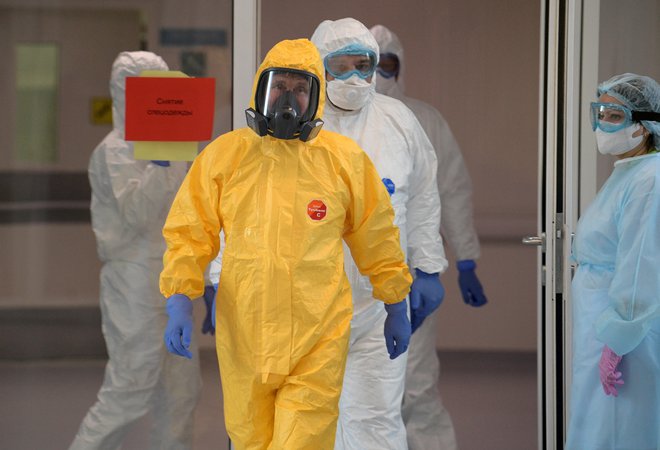 Vladimir Putin (v rumeni zaščitni opravi) na obisku v bolnišnici blizu Moskve, kjer zdravijo okužene s koronavirusom FOTO: Reuters