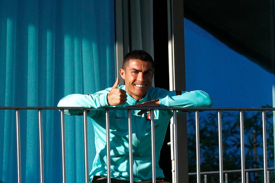 Fotografija: Cristiano Ronaldo je najprej pomahal svojim privržencem na Portugalskem, kjer se je okužil s covidom-19, nato pa odletel v Italijo, da bi se pripravil za snidenje z Lionelom Messijem. FOTO: Diogo Pinto/AFP