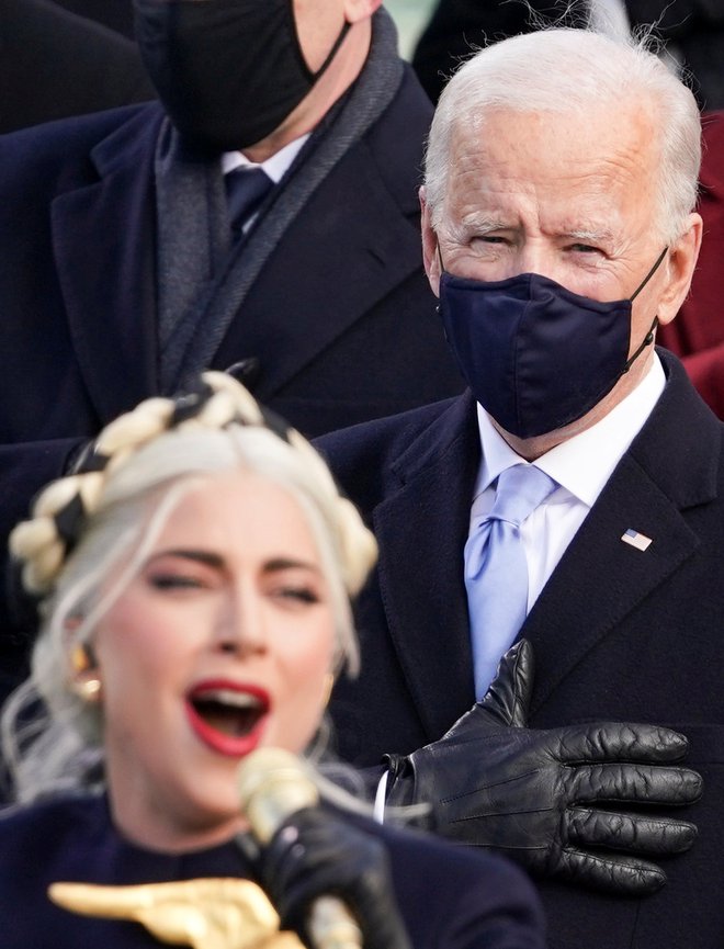 Joe Biden stoji za Lady Gaga med petjem himne, FOTO: Kevin Lamarque, Reuters