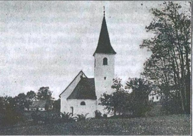Guzejeva rojstna hiša je levo od cerkve sv. Primoža pri Šentjurju.