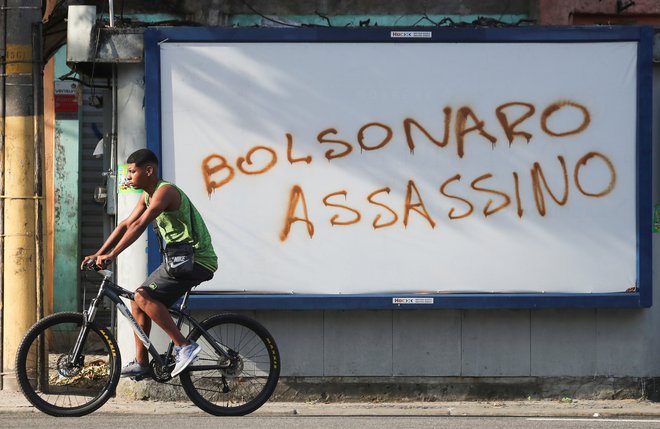 Grafit z napisom Bolsonaro, morilec zgovorno pove, kaj si ljudje mislijo o predsedniku.<br />
FOTO: SERGIO MORAES/REUTERS