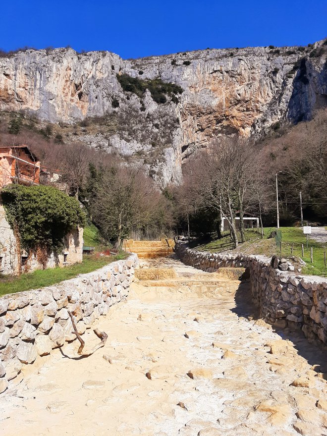 Proti jami vas usmeri običajno suha kamnita rečna struga na začetku vasi.