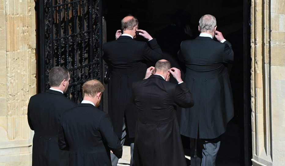 Fotografija: Člani kraljeve družine so si pred vstopom v kapelo nadeli maske. William je vsopil pred Harryjem. FOTO: Pool Reuters