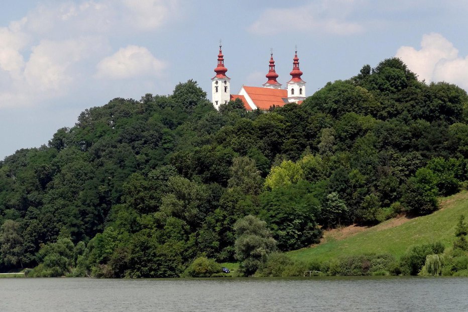 Fotografija: Nad Trojiškim jezerom se dviga cerkev sv. Trojice. FOTO: Primož Hieng
