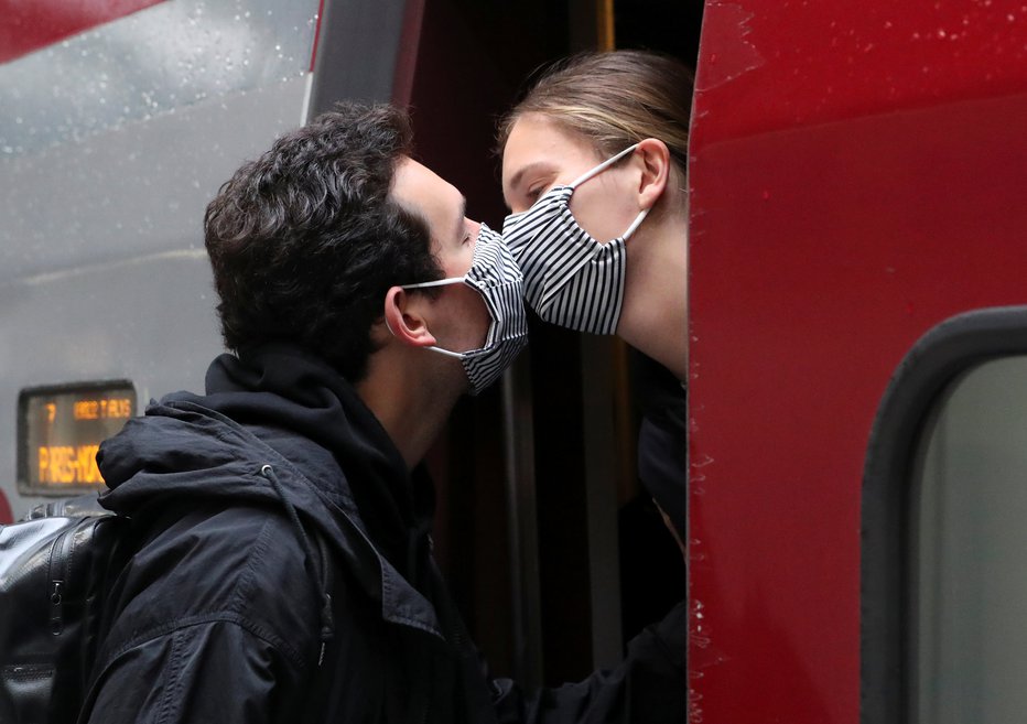 Fotografija: Poljub v maskah. FOTO: Yves Herman Reuters