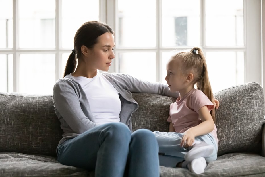 Fotografija: Serious young mom or nanny sit on couch with little preschooler girl talk sharing secrets, focused mother have conversation with small daughter, lecture or scold child, children upbringing concept
