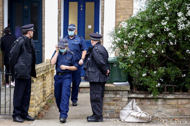 Policisti pred domom domnevnega morilca.  FOTO: Henry Nicholls, Reuters
