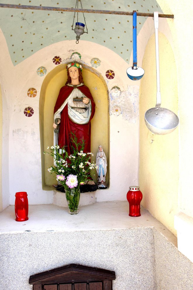 Kip sv. Lucije in zajemalki za vodo.
