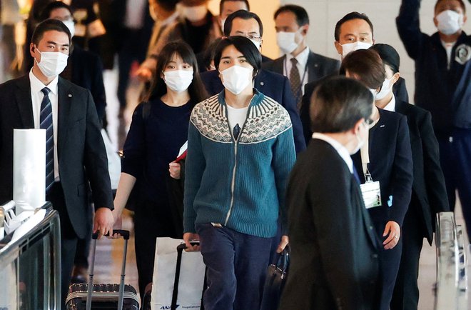 Mako in njenega moža so z letališča pospremili varnostniki. FOTO: Issei Kato/Reuters

