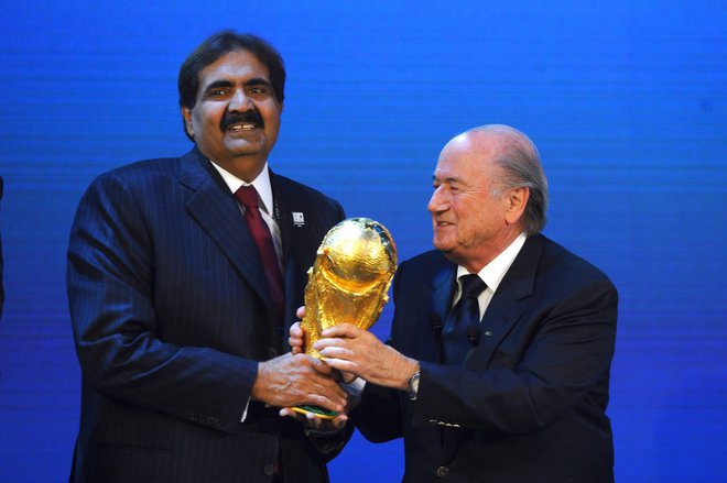 Katarski vladar Hamad bin Kalifa Al Thani je leta 2010, ko je Fifa podelila Katarju organizacijo SP 2022, iz rok takratnega predsednika svetovne nogometne organizacije Seppa Blatterja prejel pokal za svetovne prvake.
FOTO: Laurence Griffiths/Getty Images
