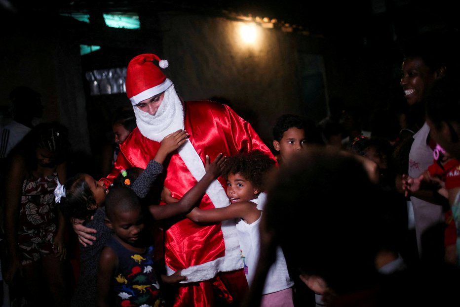 Fotografija: Najmlajši v faveli so se ga še kako razveselili. FOTOGRAFIJI: Ricardo Moraes/Reuters

