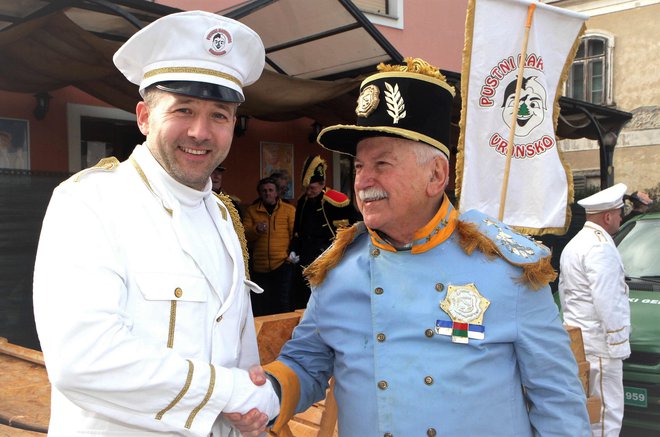 Admiral Vlado Rančigaj (desno), nekdanji glavni organizator karnevala, čestita generalu Aleksandru Reberšku za uspešno izvedbo simbolnega pustnega dogodka.
