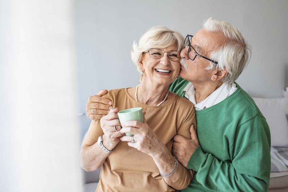 Fotografija: Portrait of smiling senior couple. Cropped portrait of a senior man affectionately embracing his wife at home. Senior man and woman standing in new house looking at camera