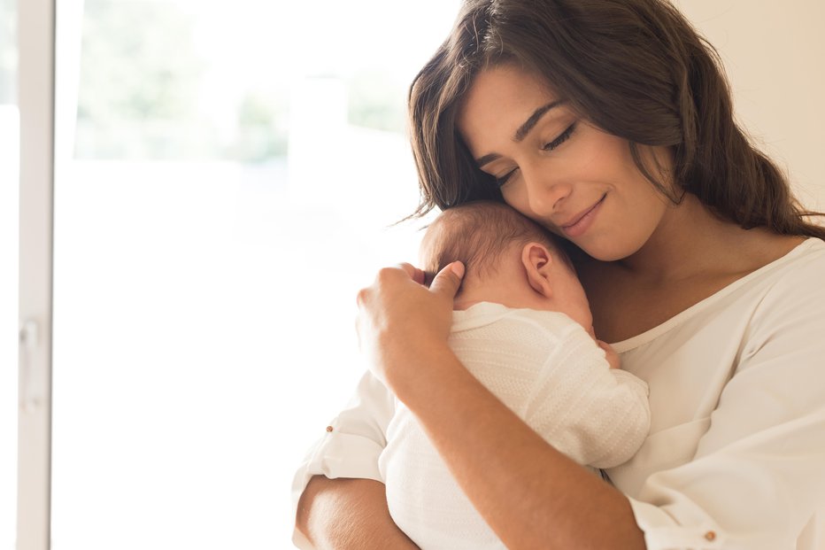 Fotografija: Pretty woman holding a newborn baby in her arms