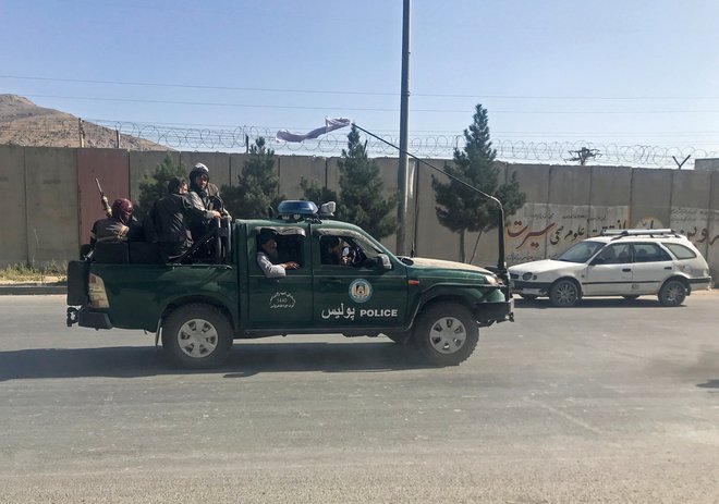 Talibani v policijskem vozilu v Kabulu. Afganistan so zavzeli v vsega desetih dneh. FOTO: Reuters