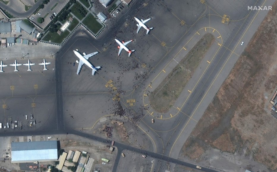 Fotografija: Z letališča so ves dan prihajali dramatični posnetki z množico ljudi na prostoru, kjer so parkirana letala za izkrcanje in vkrcanje potnikov. FOTO: Maxar Technologies/AFP