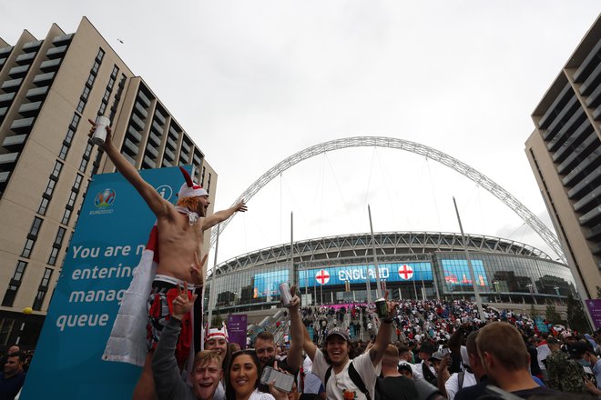 Navijači pod slavnim lokom legendarnega štadiona Wembley. FOTO: Lee Smith/Reuters