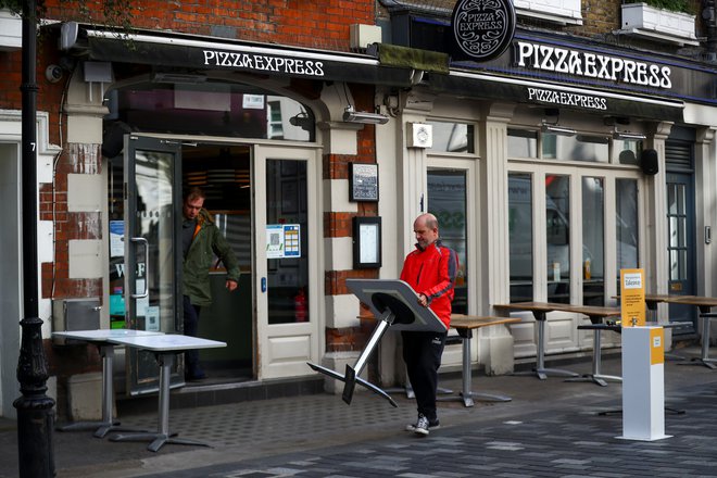 Ob sproščanju ukrepov priprave na odprtje restavracije v Londonu. FOTO: Hannah Mckay/Reuters