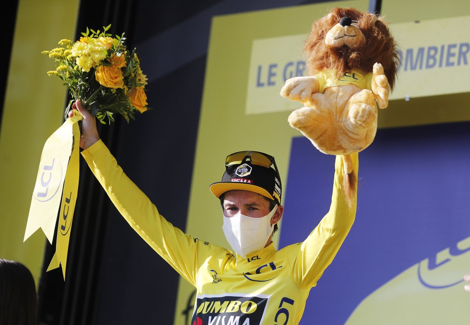 Fotografija: Primož Roglič drži v rokah rumeno majico vodilnega na dirki po Franciji. FOTO: Thibault Camus/Reuters