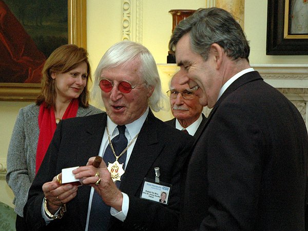 Fotografija: Večkrat odlikovani Jimmy Savile je zlorabil na stotine mladoletnih oseb. Na fotografiji z nekdanjim britanskim premierjem Gordonom Brownom. FOTO: DOWNING STREET 10
