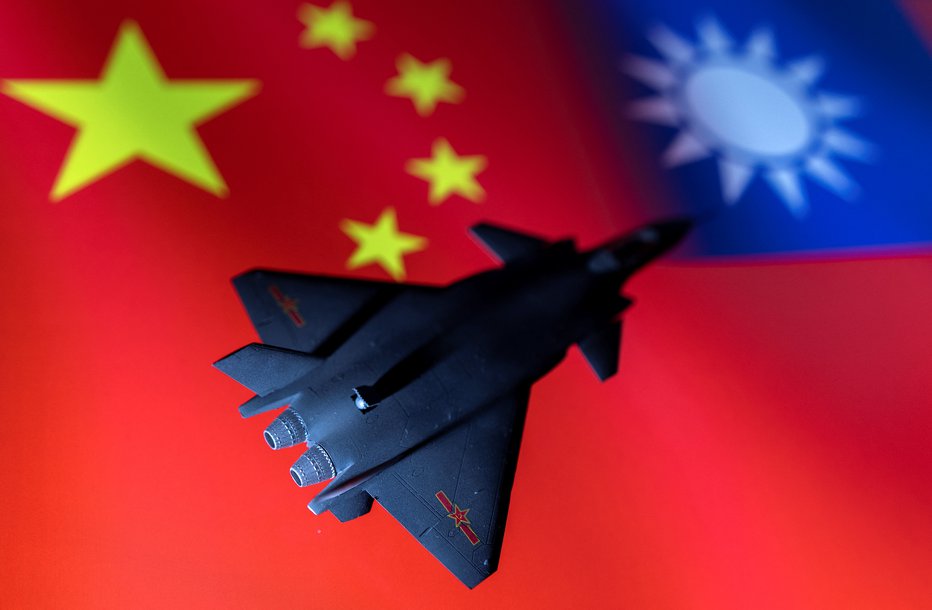 Fotografija: Model kitajskega vojnega letala, usmerjenega proti zastavi Tajvana. FOTO: Dado Ruvic, Reuters
