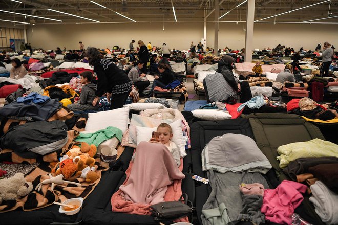 Začasni center za begunce v nekdanjem trgovskem centru v mestu Przemyśl. Na Poljsko je v minulih 13 dnevih vstopilo 1,2 milijona ukrajinskih beguncev. FOTO: Louisa Gouliamaki/AFP
