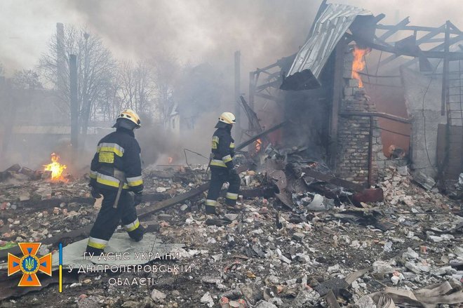 Reševalci med ruševinami v Dnipru po bombardiranju. FOTO:  Državna reševalna služba Ukrajine/Reuters
