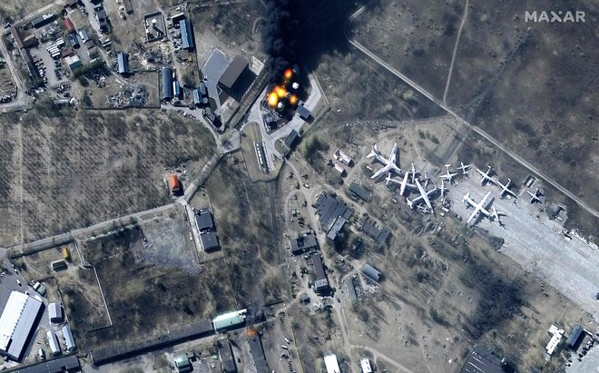 Fotografija satelita Maxar prikazuje poškodovane zgradbe in goreča skladišča goriv na letališču Antonov pri kraju Hostomel, v bližini Kijeva. FOTO: Afp/Maxar satellite
