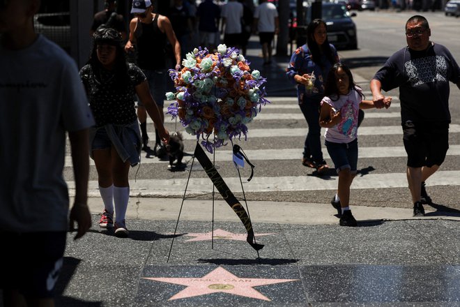 K njegovi hollywoodski zvezdi, ki jo je dobil že leta 1978, ljudje polagajo cvetje. FOTO: Mario Anzuoni/Reuters
