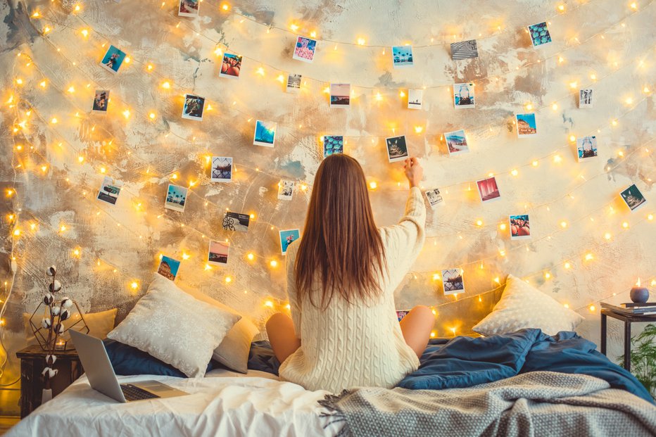 Fotografija: Božične lučke pritrdimo na steno in nanje obesimo fotografije. FOTO: Viktoriia Hnatiuk/Getty Images
