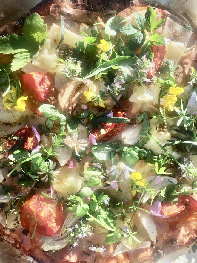 Brezglutenska vegetarijanska pica, okrašena z divjimi rastlinami: cvetovi marjetic, ivanjščic, metuljnic, divjega šipka, materine dušice, listi divjih jagod
