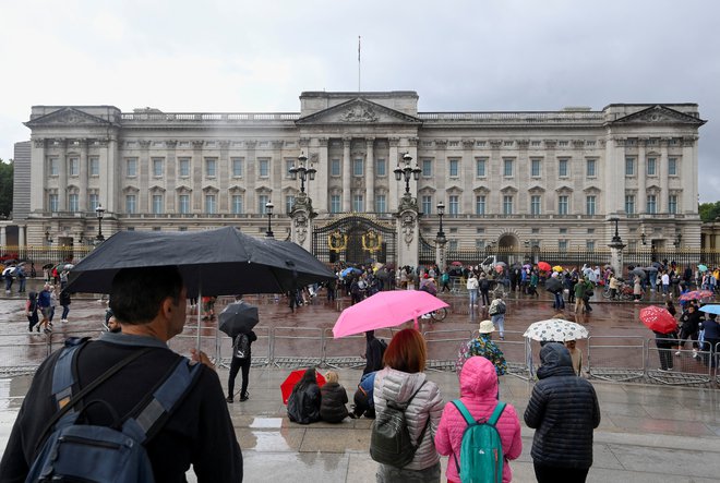 Ljudje se že zbirajo pred Buckinghamsko palačo v Londonu. FOTO: Toby Melville, Reuters

