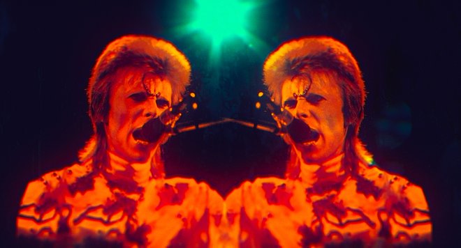 Čarovnija Davida Bowieja

V kinematografe prihaja film Moonage Daydream, biografski dokumentarec, poimenovan po pevčevi istoimenski skladbi, ki osvetljuje življenje in genialnost Davida Jonesa, bolj znanega pod umetniškim imenom Bowie. »Že pri 16 sem bil trdno odločen, da bom živel največjo pustolovščino, kar jih človek lahko živi,« pove v filmu, v katerem si lahko ogledate izkustveno kinematografsko odisejo, ki jo skozi vzvišene, kalejdoskopske in še nikoli videne posnetke, nastope in glasbo pripoveduje življenje velikega kameleonskega umetnika ter raziskuje njegovo ustvarjalno, glasbeno in duhovno potovanje. Film temelji na osebni pripovedi Davida Bowieja in je prvi uradno odobreni film o umetniku, ki ga je pohvalila tudi njegova vdova Iman.
