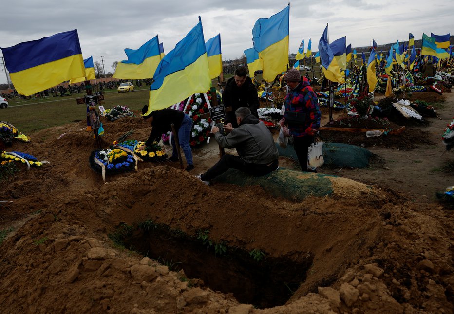 Fotografija: Kopanje grobov za padle v bojih v Harkovu. FOTO: Clodagh Kilcoyne, Reuters
