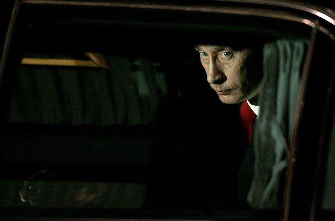 Vladimir Putin gleda iz svojega avtomobila. FOTO: Stoyan Nenov, Reuters
