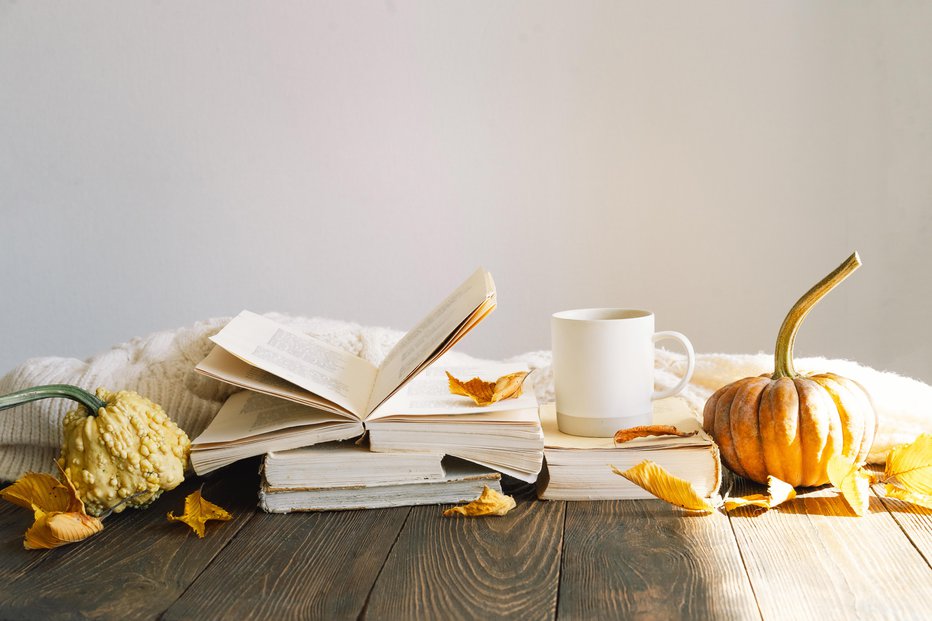 Fotografija: Cozy autumn background, decorative pumpkin, dried flowers, books, warm sweaters. Reading in the autumn day. Autumn books. Autumn reading. Cozy mood. Space for text, top view.